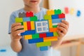 Plastic toy blocks, designer of children`s toys. Bright building blocks in the shape of a heart in children`s hands Royalty Free Stock Photo