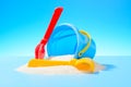 Plastic toy bucket, rake and shovel in the sand Royalty Free Stock Photo