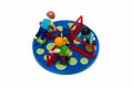 Plastic toy children figures playing in blue park wheel with yellow circles isolated