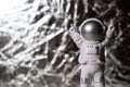 Plastic toy figure astronaut on silver background Copy space. Concept of out of earth travel, private spaceman