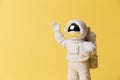 Plastic toy figure astronaut on a yellow background. Copy space. Close-up