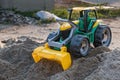 Plastic toy front loader on the sand pile Royalty Free Stock Photo
