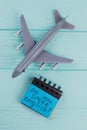 Plastic toy passenger jet plane and sticky paper on blue wooden background. Royalty Free Stock Photo