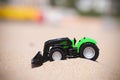 Plastic Toy tractor in the sand. Royalty Free Stock Photo
