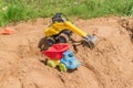 Plastic toys in a sandbox outdoors. Truck and excavator  for playing in the sand Royalty Free Stock Photo