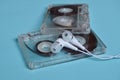 Plastic transparent audio cassette and white vacuum headphones on a bright blue background.