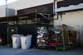 Plastic trash bins and bundles of cardboard near industrial building