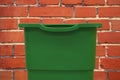 Plastic trash can green object for cleaning with empty space for copy or your text here on brick wall background texture Royalty Free Stock Photo