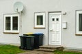 Plastic trash cans near the entrance to a residential building. Royalty Free Stock Photo