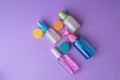 Plastic travel bottles on lavender background. Travel containers with colorful tops.