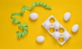 Plastic tray with white eggs and a ruler on a yellow pastel background, minimalism trend, top view. Royalty Free Stock Photo