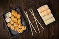 Plastic trays with various rolls and chopsticks on a wooden table in close-up Royalty Free Stock Photo