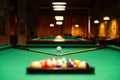 Plastic triangle rack with billiard balls and cues on green table indoors, selective focus Royalty Free Stock Photo