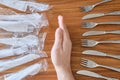 Plastic versus reusable cutlery concept: Man hand between disposable plastic sets and a stainless steel fork / knife set.