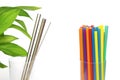 Plastic vs eco steel straw. reusable sustainable cocktail metal straw with special brush and green leaf and a lot of multi-colored Royalty Free Stock Photo