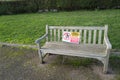 Plastic warning sign tied to a Woden public bench advising people to maintain social distancing to avoid the spread of Covid-19