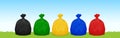 Plastic waste bags black, green, yellow, blue and red on the grass and sky background, set of colored garbage waste bags plastic