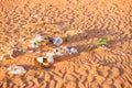 Plastic waste, bags packaging and other rubbish trash abandoned in a pristine sand desert environment biodegrading under a harsh