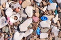 Plastic waste covers and garbage on pebble seashore after storm, closeup view. Royalty Free Stock Photo