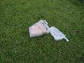 plastic waste lying on green grass used for food that has been thrown away carelessly