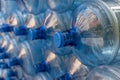 Plastic water bottle background, blue bottle caps, orderly arrangement. Empty bottles for drinking water. Heap of empty plastic dr