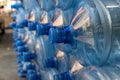 Plastic water bottle background, blue bottle caps, orderly arrangement. Empty bottles for drinking water. Heap of empty plastic dr