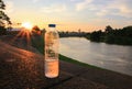 Plastic water bottle on the stone floor in a public park at sunset, sunrise time Royalty Free Stock Photo