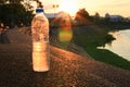 Plastic water bottle on the stone floor in a public park at sunset, sunrise time Royalty Free Stock Photo