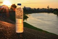 Plastic water bottle on the stone floor in a public park at sunset, sunrise time Royalty Free Stock Photo