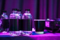 Plastic water bottles with blank black labels in the dark and purple lighting. Royalty Free Stock Photo