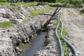 Plastic water pipe lying along the ditch with high groundwater, water connection in the housing estate.