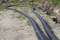 Plastic water pipe lying along the ditch with high groundwater, water connection in the housing estate.