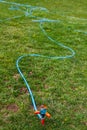 Plastic Water Pipe Sprinkler on Green Grass