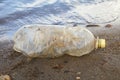 Water pollution problem, crumpled plastic bottle floating in ocean