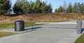 Plastic white barrier Cameras and black waste garbage container installed near the forest parking