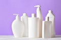 Plastic white bottles on a light purple background. L Royalty Free Stock Photo