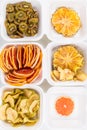 The plastic white containers contain sliced dried fruits, apple, kiwi, pineapple and grapefruit Royalty Free Stock Photo