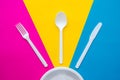 Plastic white fork, knife, spoon and plate on multicolored background. Cooking utensil. Top view. Minimalist Style. Copy, empty Royalty Free Stock Photo