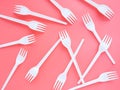 Plastic white forks are scattered on a pink background, flat lay, top view. A bright modern concept of the problem of ecology. Non Royalty Free Stock Photo