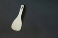 Plastic white spoon for multicooker on a dark background close-up Royalty Free Stock Photo