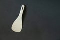 Plastic white spoon for multicooker on a dark background close-up Royalty Free Stock Photo