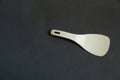 Plastic white spoon for multicooker on a dark background close-up Royalty Free Stock Photo