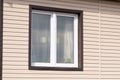Plastic white window on the beige wall house from the siding Royalty Free Stock Photo