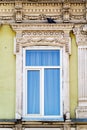 A plastic window in the wall of an old building with stucco molding, a fragment of the facade