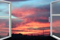 Plastic windows overlooking beautiful crimson sunset. View from home window