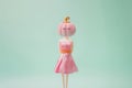 Plastic woman doll in a pink dress with pink Halloween pumpkin head and black eyelashes on green mint background