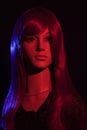 Mannequin with bright long red hair posing on a black background