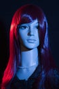 Mannequin with bright long red hair posing on a black background