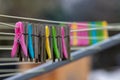 Mixture of plastic and wooden clothes pegs hanging from a clothes line. Air drying is more environmentally friendly than using a c Royalty Free Stock Photo