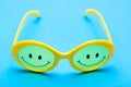 Plastic yellow sunglasses with painted eyes and a smile on the glass Royalty Free Stock Photo